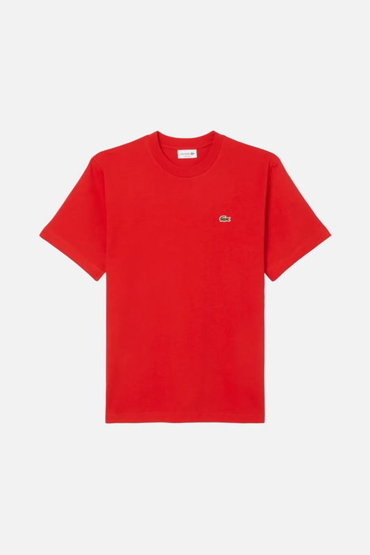 Red t-shirt with a small logo on a light gray background